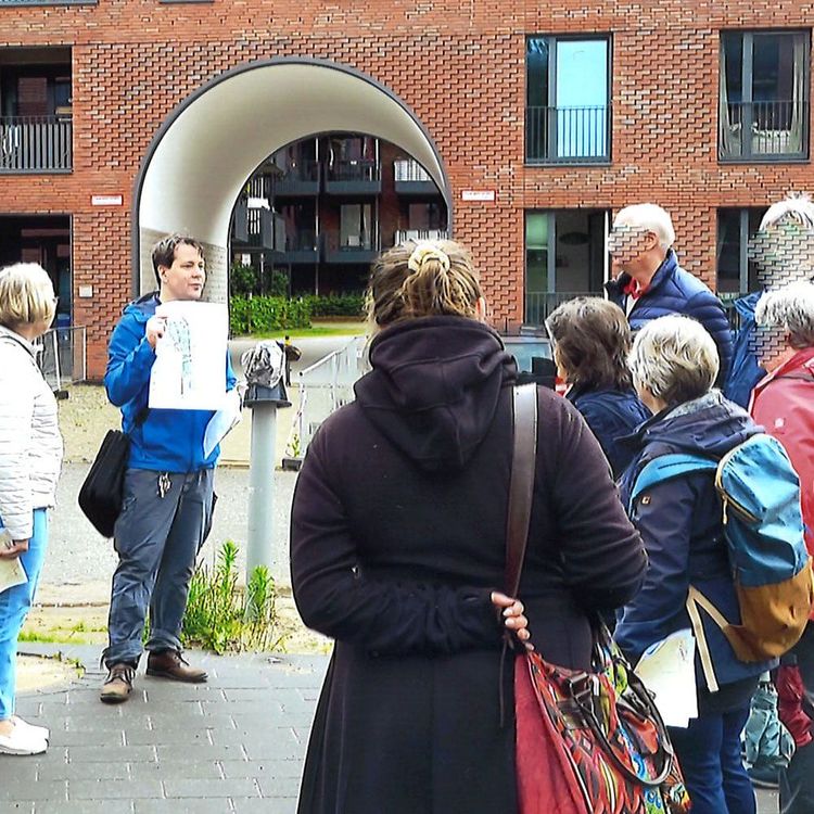 Dr. Stefan Brauckmann zeigt Teilnehmen einer Exkursion verschiedene Pläne im Pergolenviertel (Bezirk Hamburg-Nord)